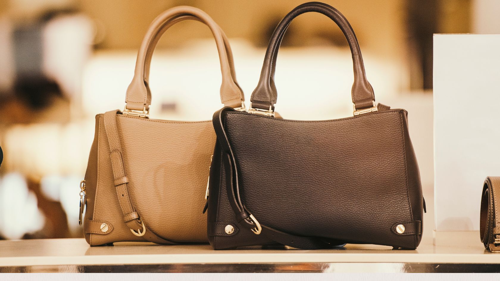Two luxury, brown purses showcased on a table
